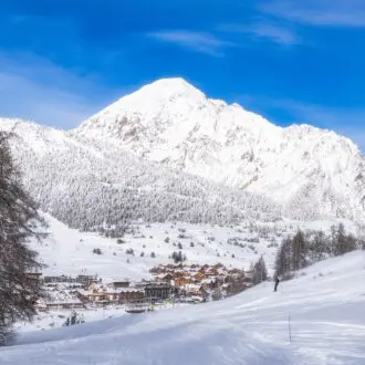 The stunning view of snowcovered mountains contrasts with the vibrant blue sky, highlighting winters beauty in a peaceful environment, ideal for exploration, Montgenèvre ski village, Alps, France